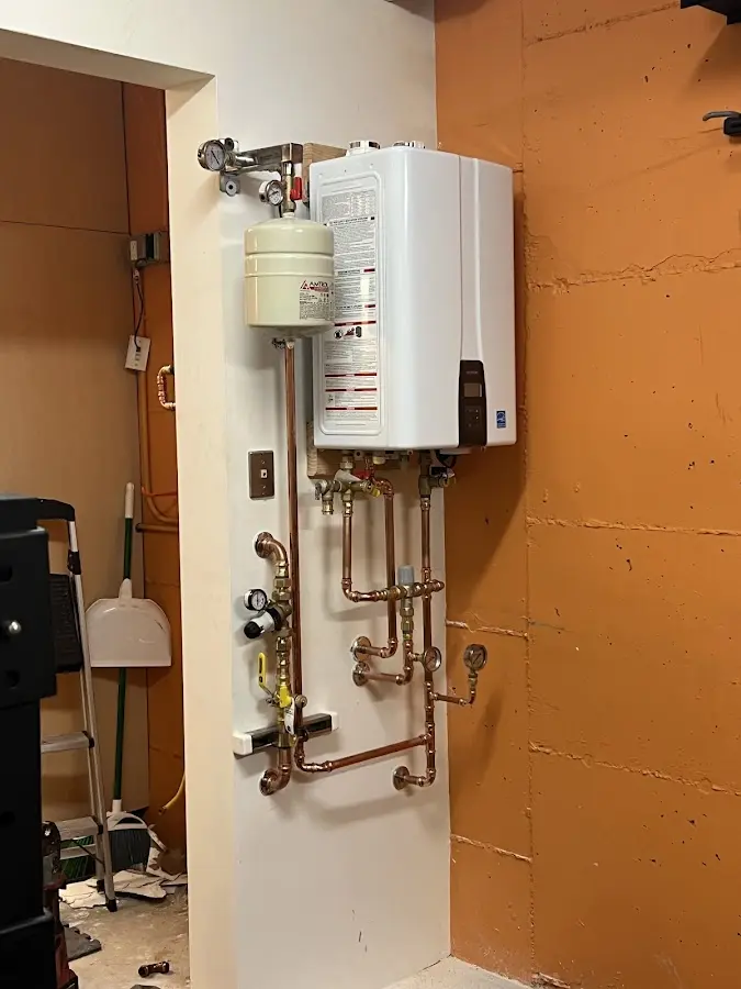 Plumbing technician inspecting water heater connections in Gunnison